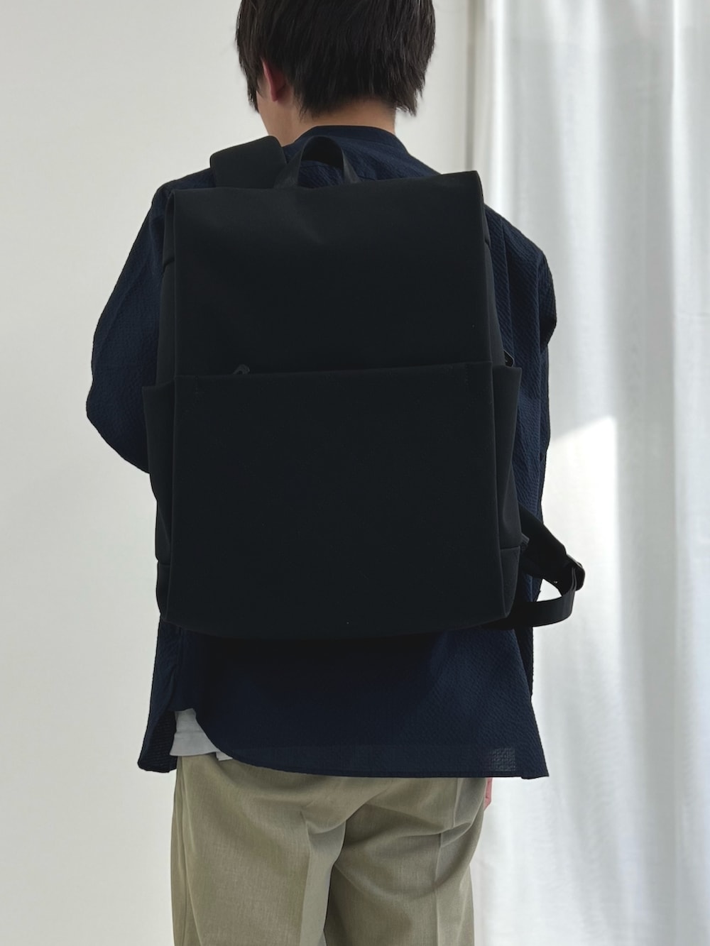 ブラック系のバックパック/リュック、ブラック系のサンダル、ブルー系のシャツ/ブラウスを着用したメンズの春コーディネートの7枚目の写真