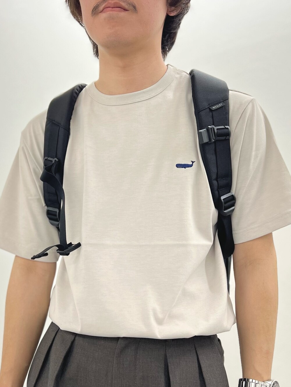 ベージュ系のTシャツ/カットソー、ブラック系のバックパック/リュック、ブラック系のサンダルを着用したメンズの春コーディネートの7枚目の写真