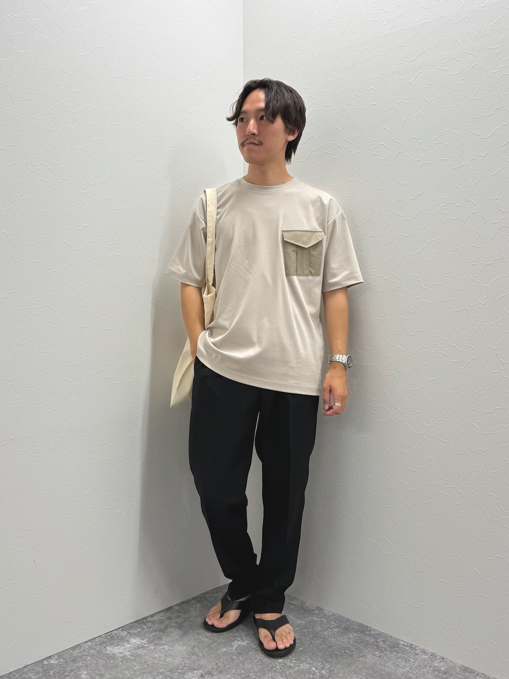 ベージュ系のTシャツ/カットソー、ホワイト系のトートバッグ、ブラック系のその他パンツを着用したメンズの夏コーディネートの3枚目の写真