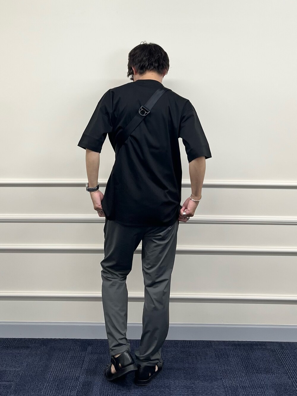 ブラック系のTシャツ/カットソー、グリーン系のショルダーバッグ、グレー系のその他パンツを着用したメンズの春コーディネートの7枚目の写真