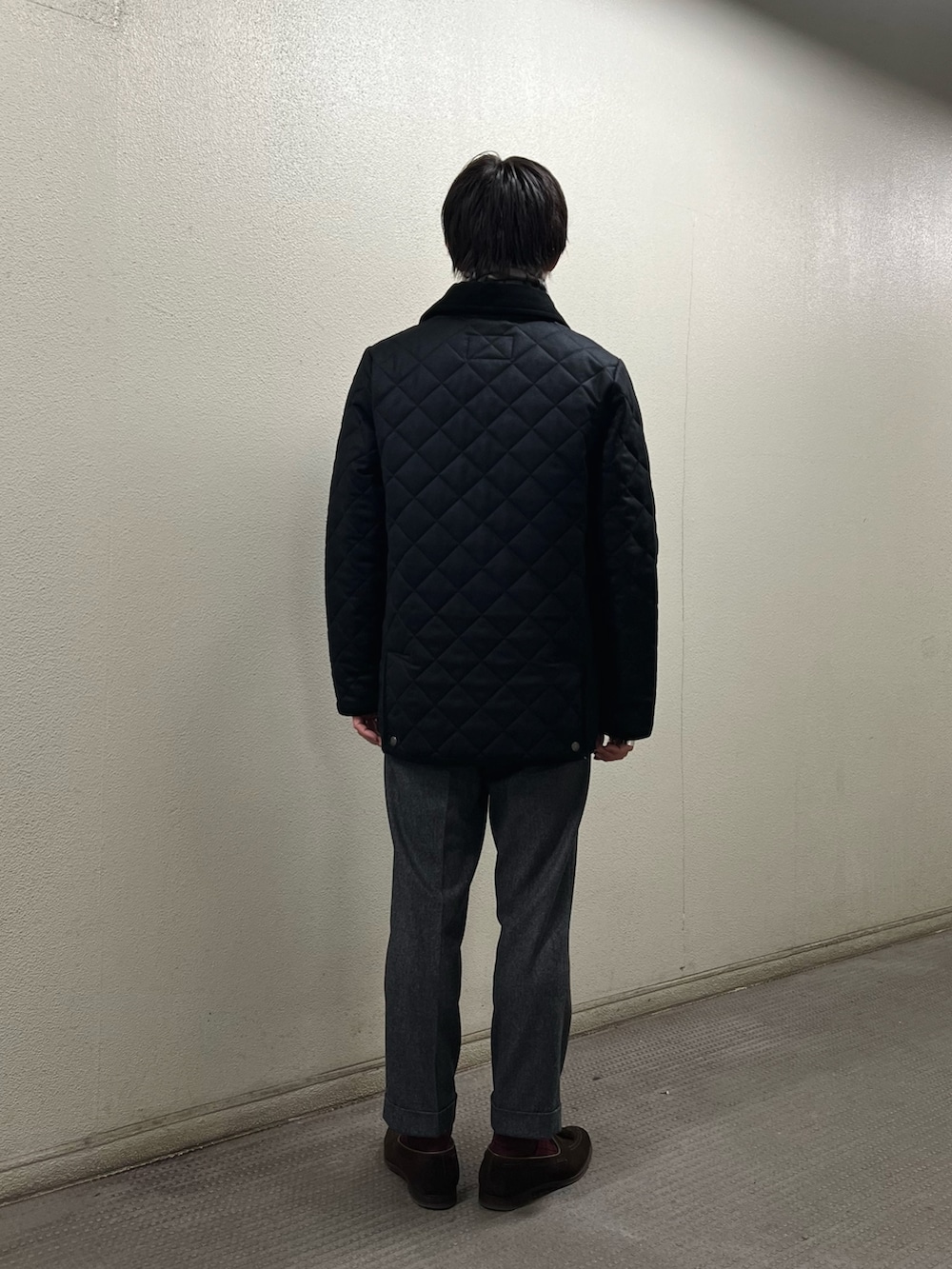 ブラック系のブルゾン、ホワイト系のマフラーを着用したメンズの冬コーディネートの4枚目の写真