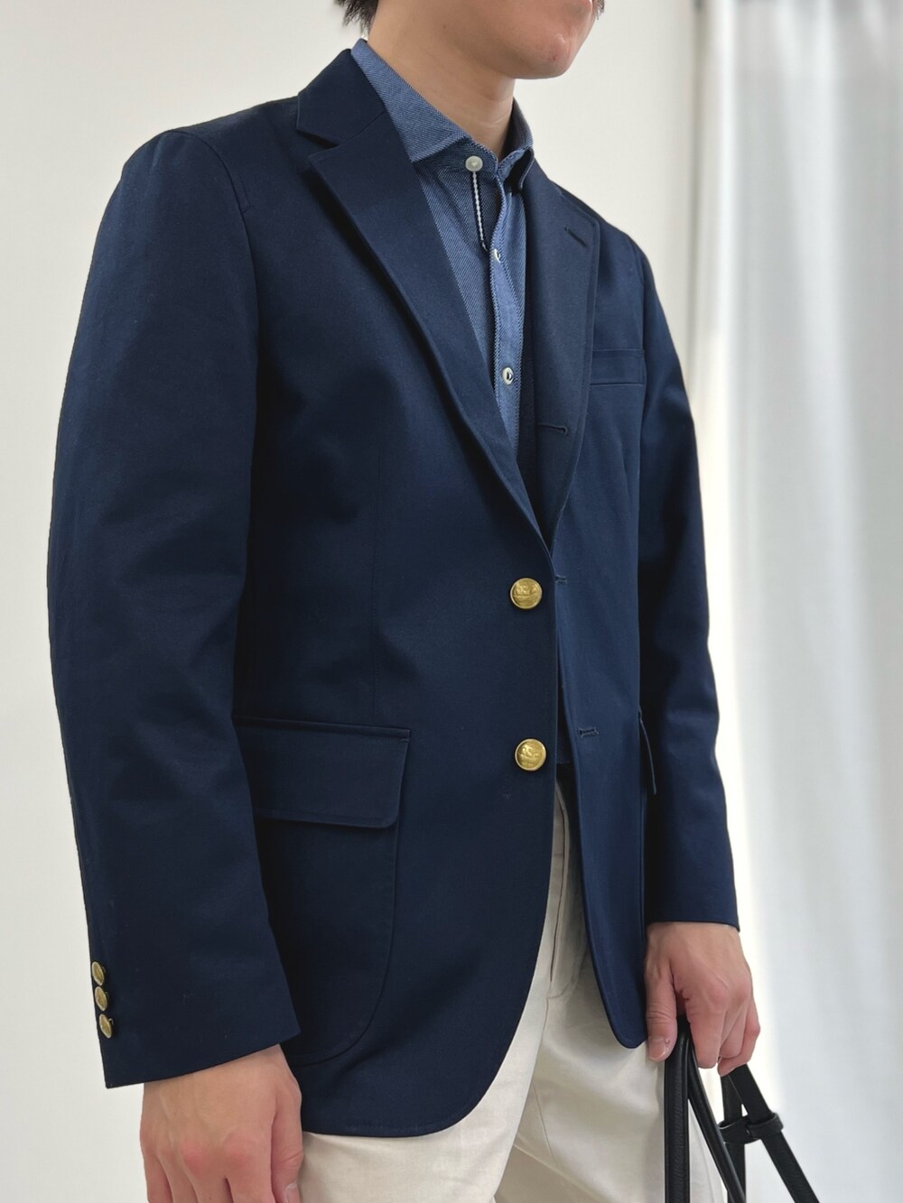 ブルー系のシャツ/ブラウス、ホワイト系のチノパンツ、ブラック系のローファーを着用したメンズの春コーディネートの7枚目の写真