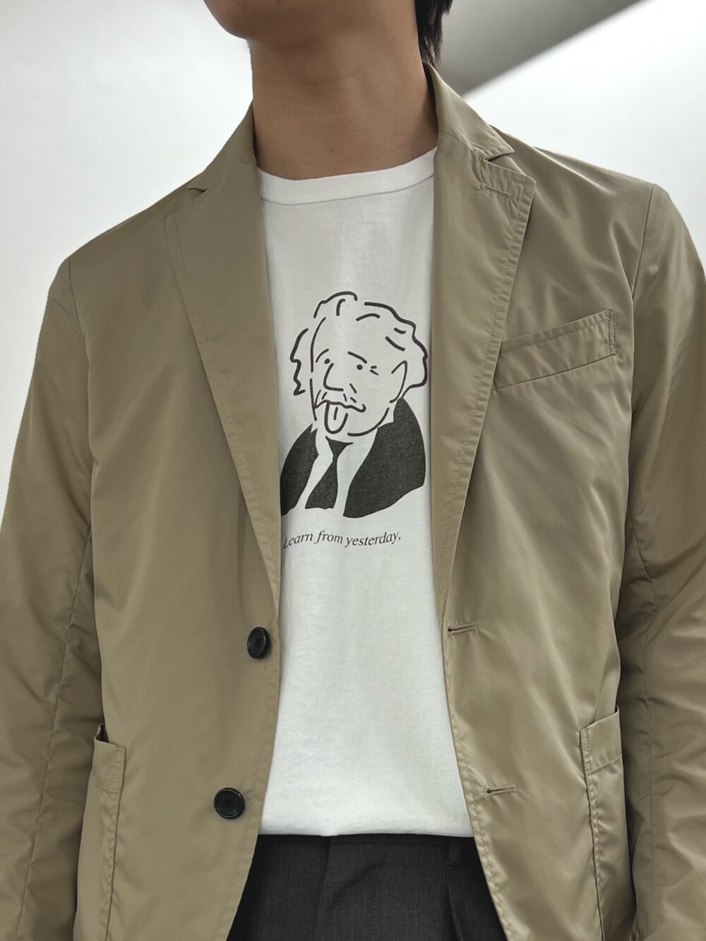 ベージュ系のテーラードジャケット、ホワイト系のTシャツ/カットソー、ブラック系のサンダルを着用したメンズの春コーディネートの6枚目の写真