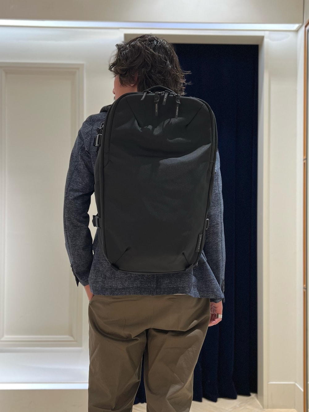 ホワイト系のTシャツ/カットソー、ブラック系のバックパック/リュック、ブラック系のその他シューズを着用したメンズの春コーディネートの10枚目の写真