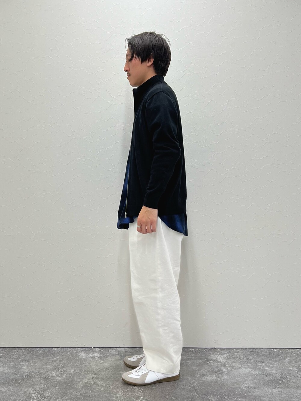 ブラック系のカーディガン/ボレロ、ブルー系のシャツ/ブラウス、ホワイト系のデニムパンツを着用したメンズの冬コーディネートの5枚目の写真
