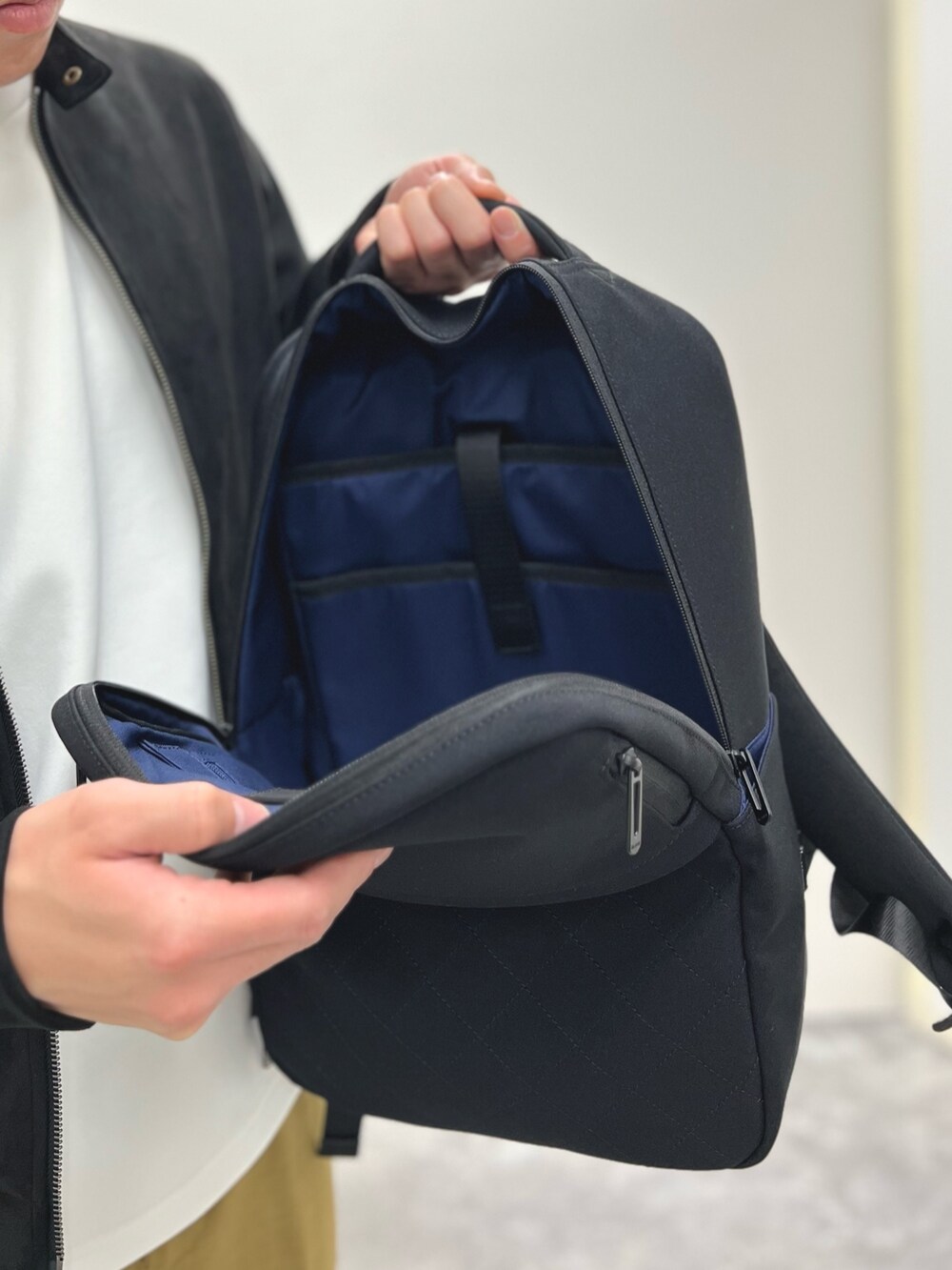 ブラック系のブルゾン、ベージュ系のその他パンツ、ブラック系のサンダルを着用したメンズの春コーディネートの6枚目の写真