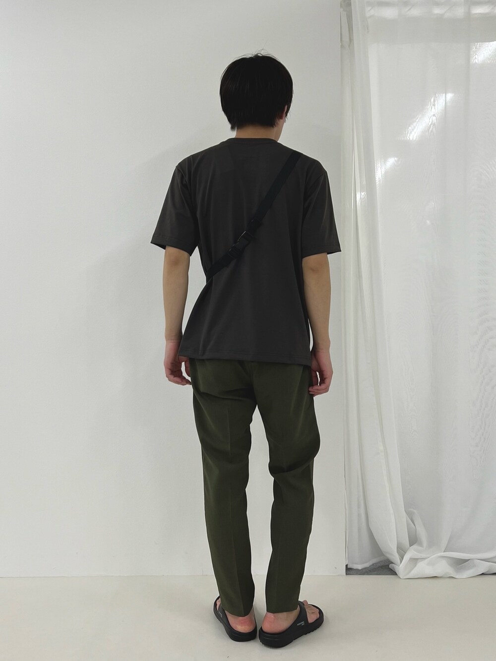 グレー系のTシャツ/カットソー、ブラック系のサンダル、ブラック系のショルダーバッグを着用したメンズの春コーディネートの4枚目の写真