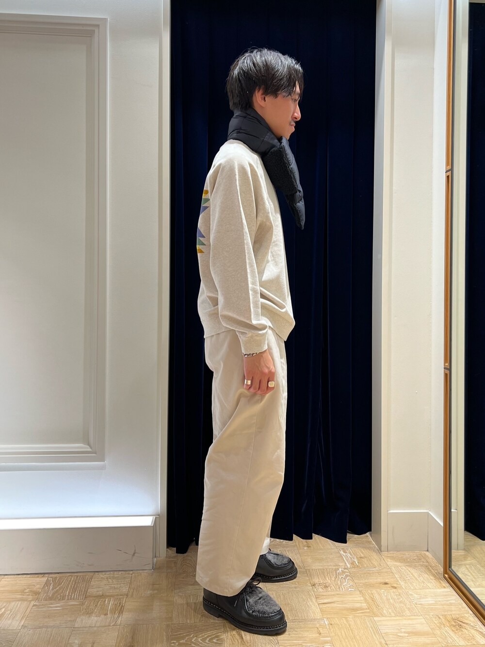 ホワイト系のスウェット、ブラック系のマフラーを着用したメンズの秋コーディネートの3枚目の写真