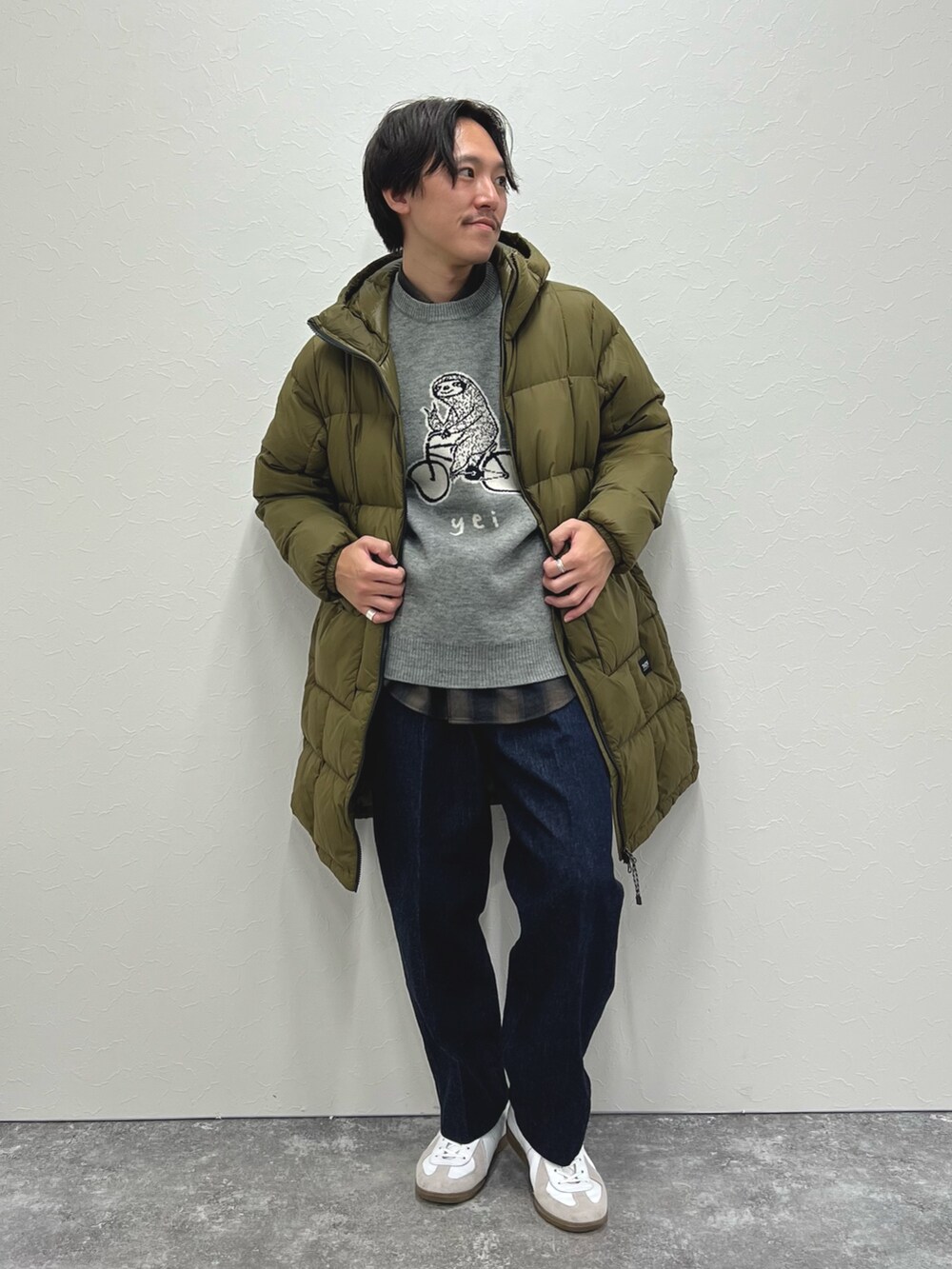 グリーン系のダウンジャケット/コート、グレー系のニット/セーター、グリーン系のシャツ/ブラウスを着用したメンズの冬コーディネートの2枚目の写真