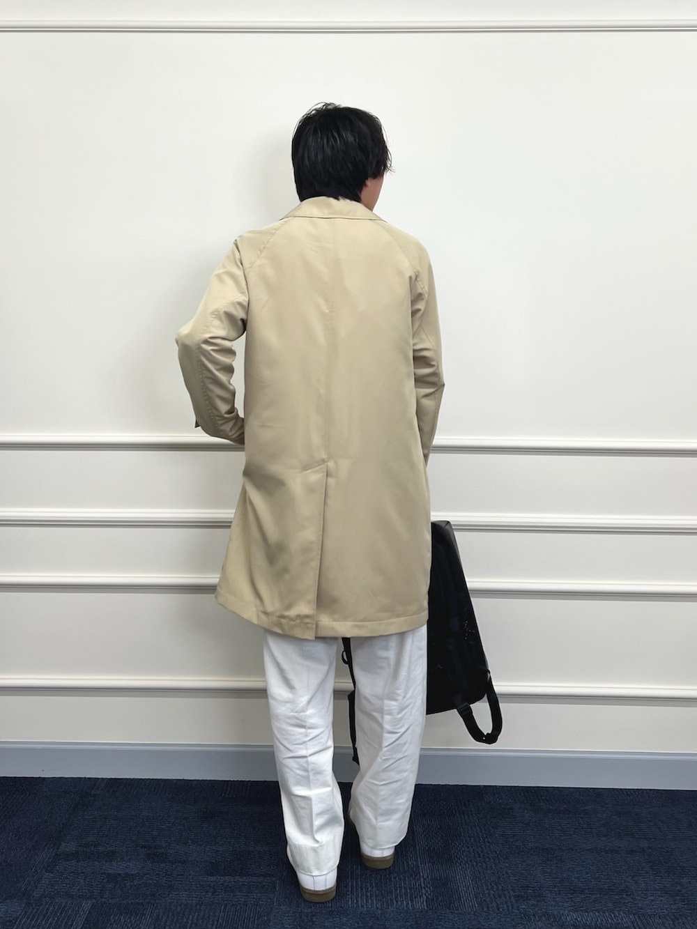 ベージュ系のステンカラーコート、ブラック系のシャツ/ブラウス、ホワイト系のデニムパンツを着用したメンズの冬コーディネートの8枚目の写真