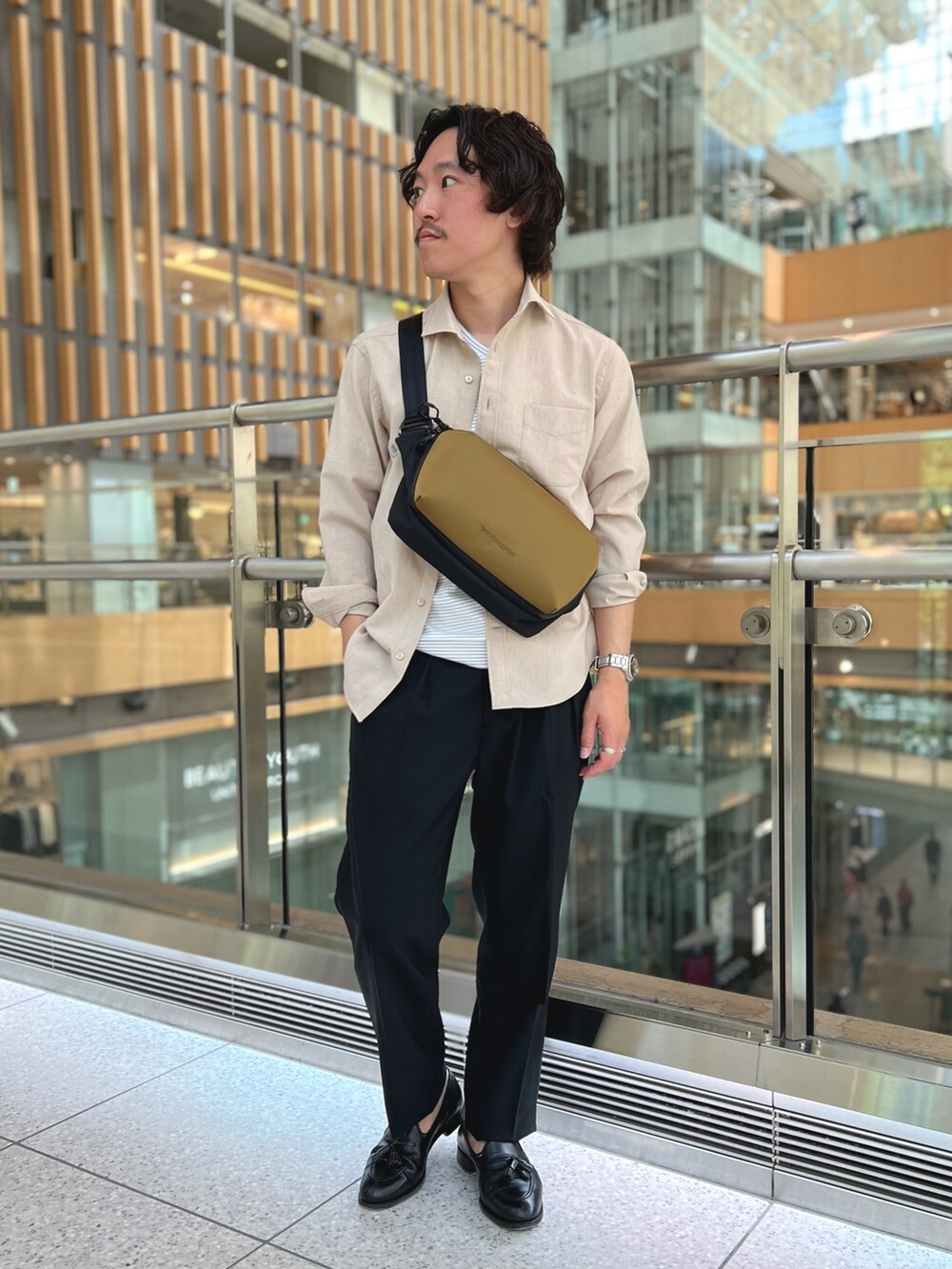ベージュ系のシャツ/ブラウス、ホワイト系のTシャツ/カットソー、ブラック系のスラックスを着用したメンズの春コーディネートの4枚目の写真