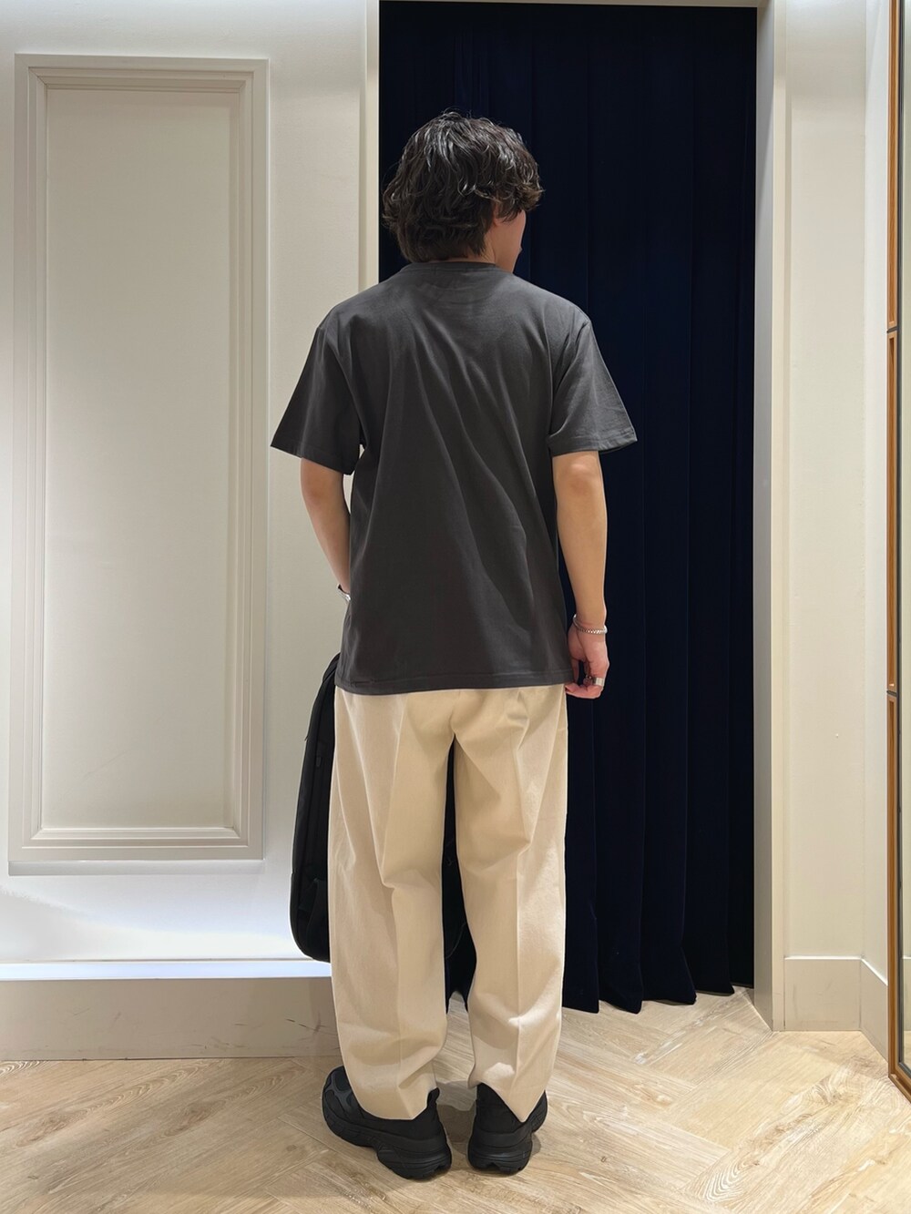 ブラック系のTシャツ/カットソー、ブラック系のバックパック/リュック、ブラック系のスニーカーを着用したメンズの春コーディネートの6枚目の写真