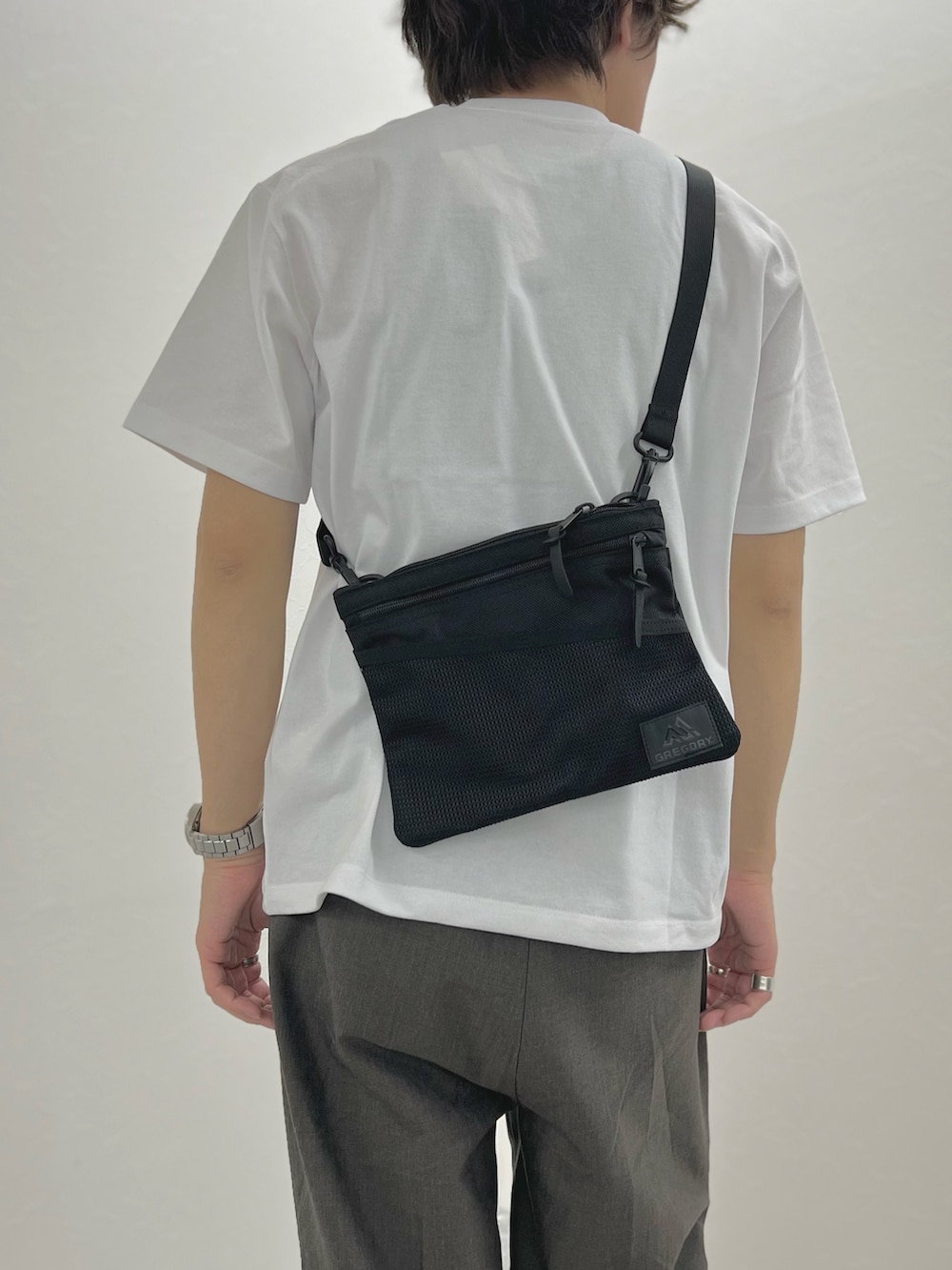 ホワイト系のTシャツ/カットソー、ブラック系のショルダーバッグ、ブラック系のサンダルを着用したメンズの春コーディネートの9枚目の写真
