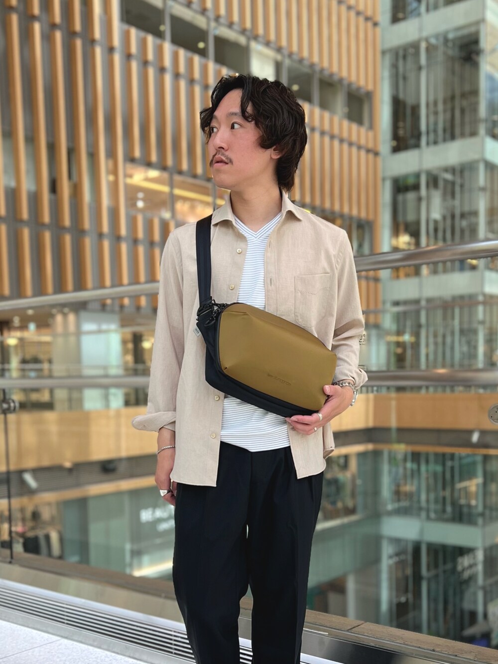 ベージュ系のシャツ/ブラウス、ホワイト系のTシャツ/カットソー、ブラック系のスラックスを着用したメンズの春コーディネートの3枚目の写真