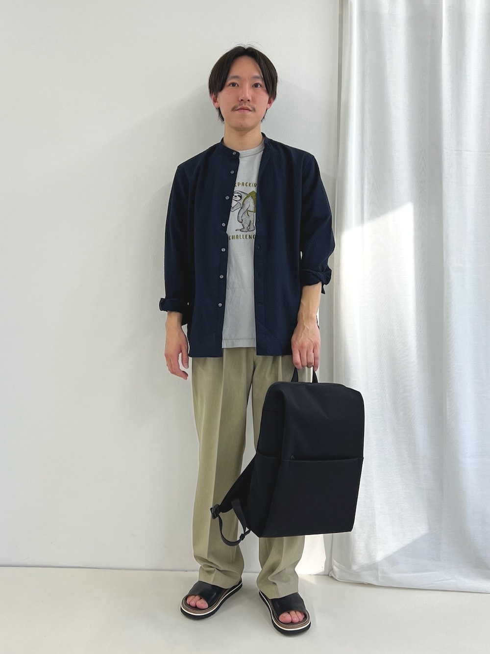 ブラック系のバックパック/リュック、ブラック系のサンダル、ブルー系のシャツ/ブラウスを着用したメンズの春コーディネートの3枚目の写真