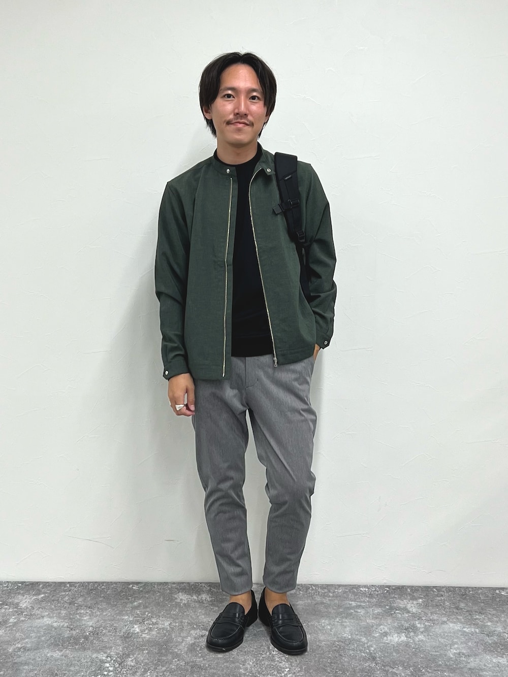グリーン系のブルゾン、ブラック系のTシャツ/カットソー、グレー系のその他パンツを着用したメンズの夏コーディネートの3枚目の写真
