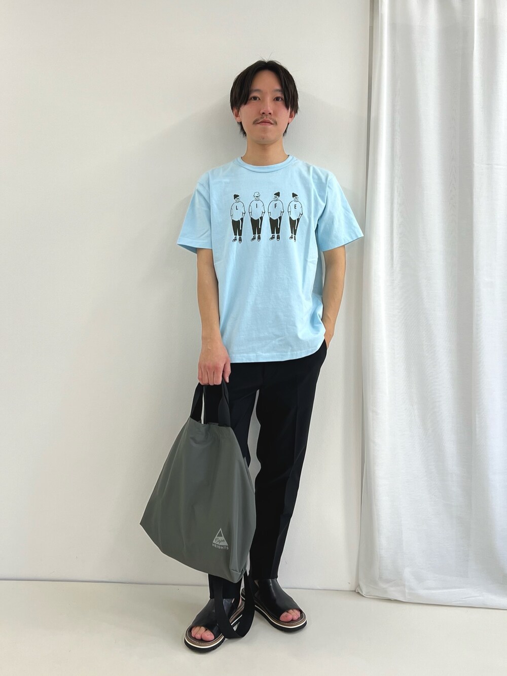 ブルー系のTシャツ/カットソー、ブラック系のその他パンツ、グレー系のトートバッグを着用したメンズの春コーディネートの2枚目の写真