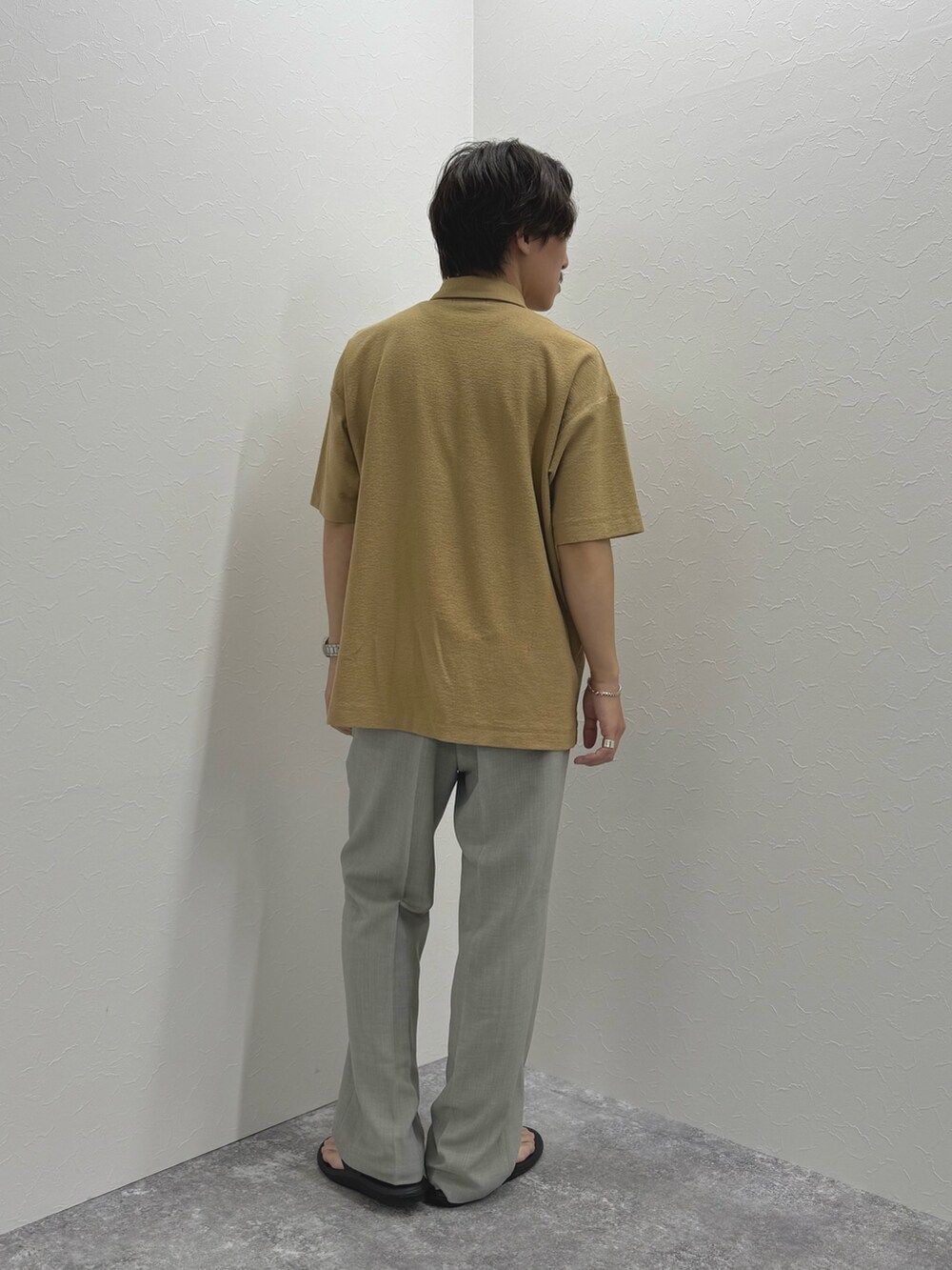 ベージュ系のポロシャツ、ブラック系のサンダルを着用したメンズの夏コーディネートの7枚目の写真