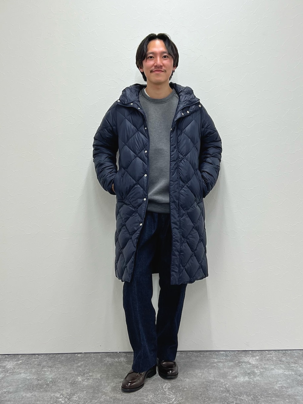 ブルー系のダウンジャケット/コート、グレー系のスウェット、ブルー系のデニムパンツを着用したメンズの冬コーディネートの2枚目の写真