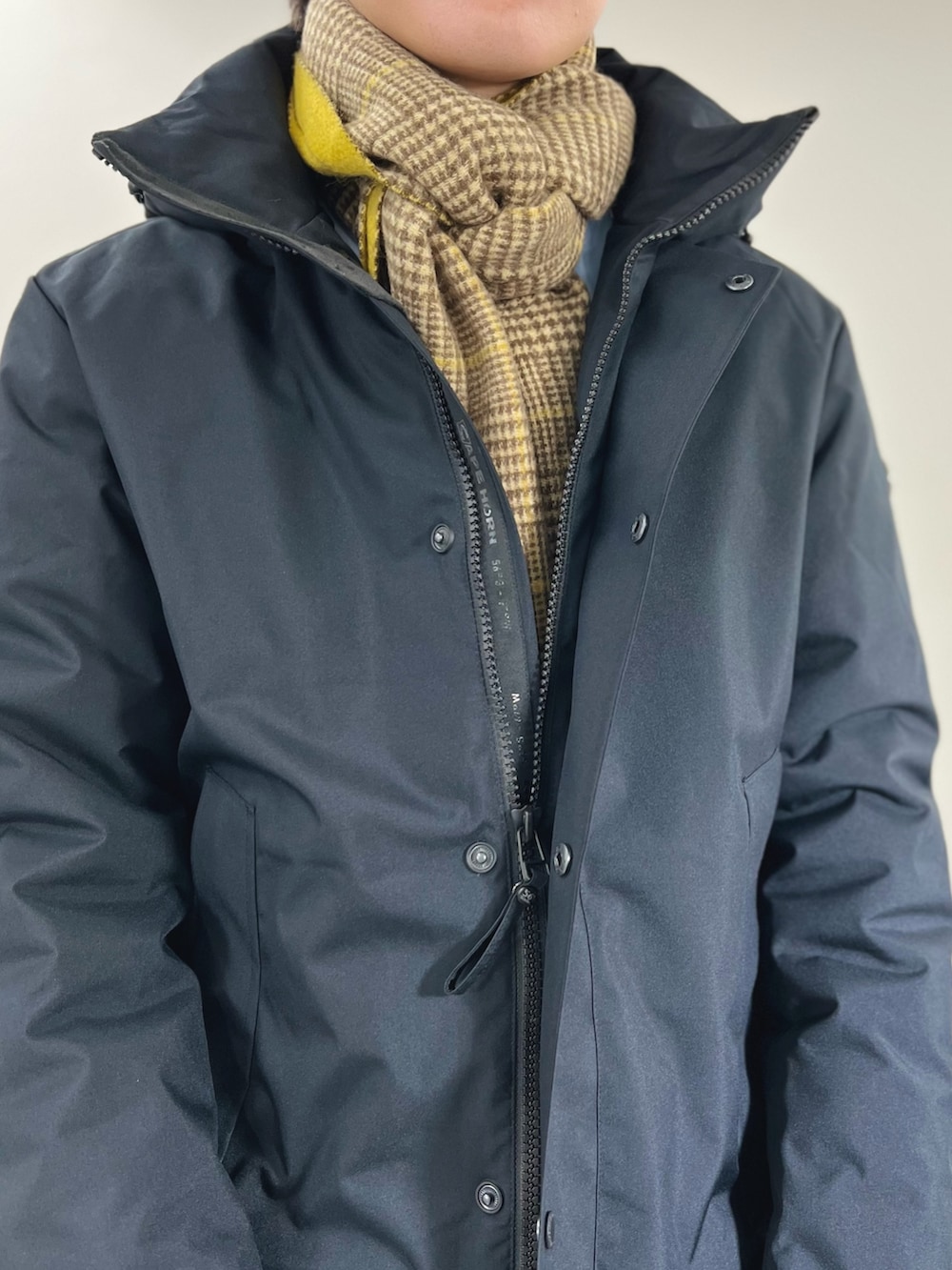 ブラック系のダウンジャケット/コート、ブルー系のシャツ/ブラウス、イエロー系のマフラーを着用したメンズの冬コーディネートの7枚目の写真