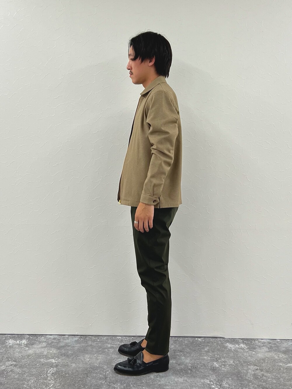 ベージュ系のブルゾン、ブラック系のTシャツ/カットソー、グリーン系のその他パンツを着用したメンズの秋コーディネートの5枚目の写真