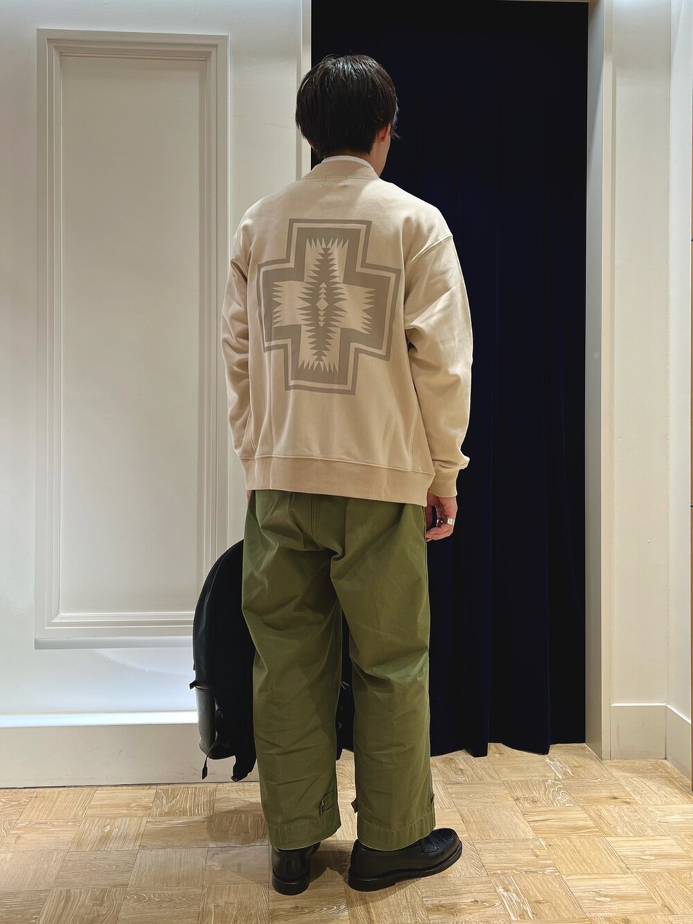 ブラック系のバックパック/リュック、ブラック系のローファー、グリーン系のパンツを着用したメンズの秋コーディネートの4枚目の写真