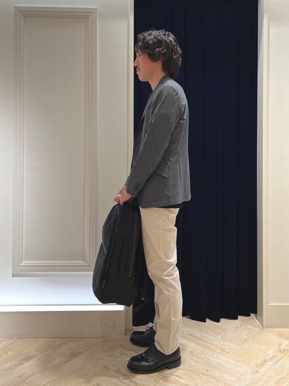 グレー系のテーラードジャケット、ブラック系のTシャツ/カットソー、ホワイト系のチノパンツを着用したメンズの春コーディネートの5枚目の写真
