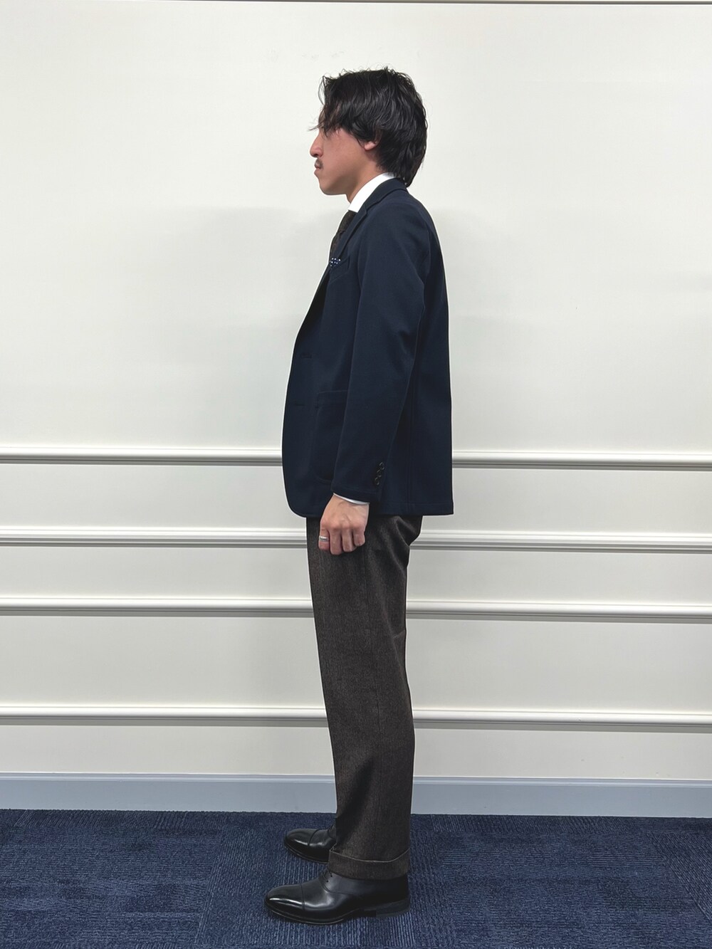 ブルー系のテーラードジャケット、ホワイト系のシャツ/ブラウス、ブラウン系のスラックスを着用したメンズの冬コーディネートの5枚目の写真