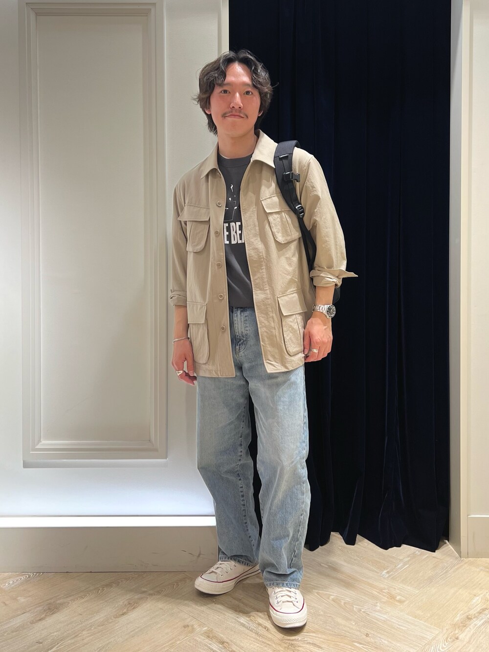 ベージュ系のミリタリージャケット、ブラック系のTシャツ/カットソー、ブラック系のバックパック/リュックを着用したメンズの春コーディネートの3枚目の写真