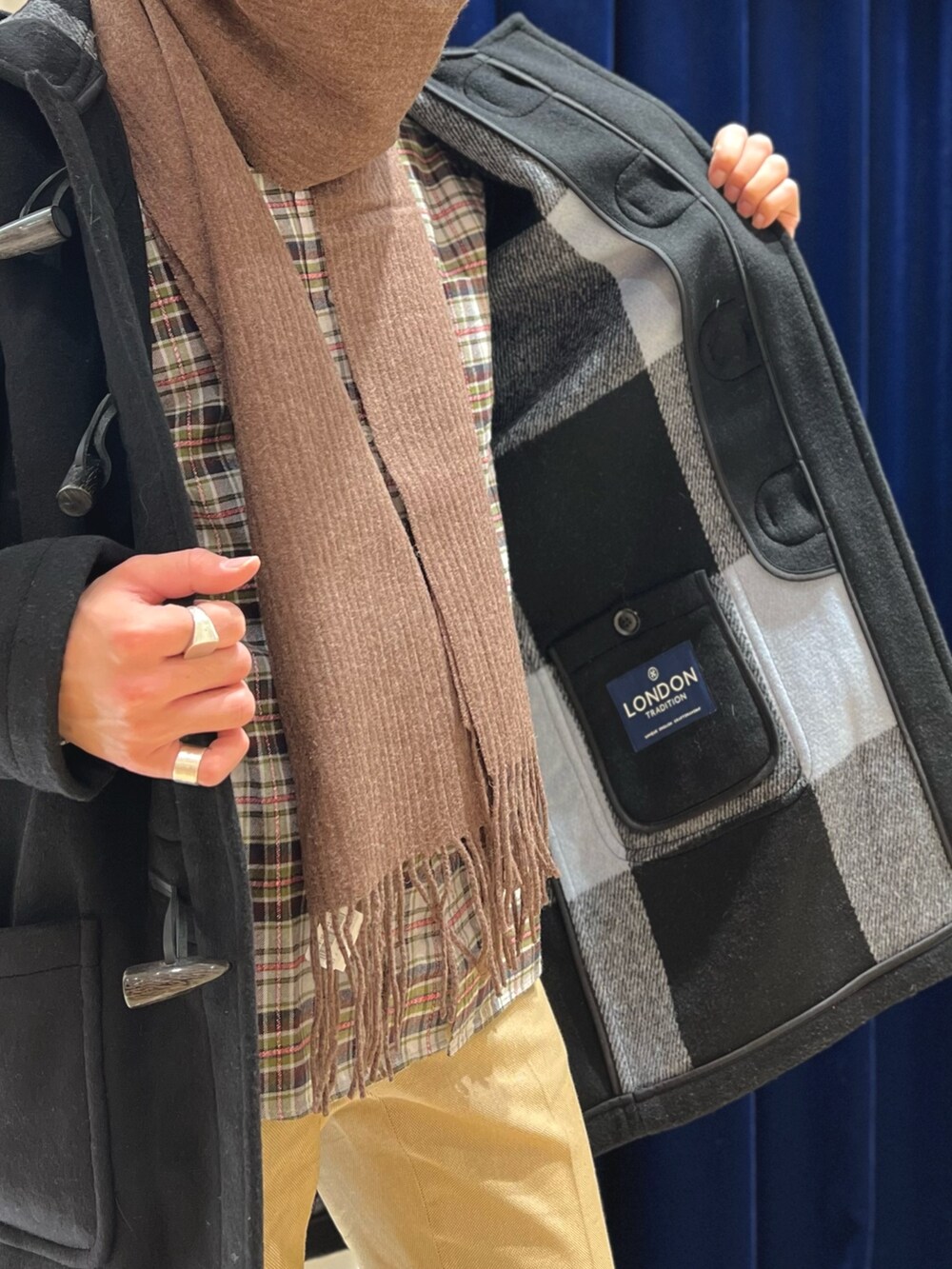 ブラック系のシャツ/ブラウス、ブラック系のダッフルコート、ベージュ系のその他パンツを着用したメンズの冬コーディネートの8枚目の写真