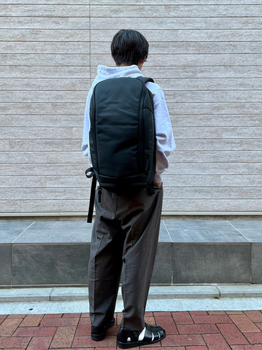 グレー系のパーカー、ブラック系のバックパック/リュックを着用したメンズの秋コーディネートの3枚目の写真