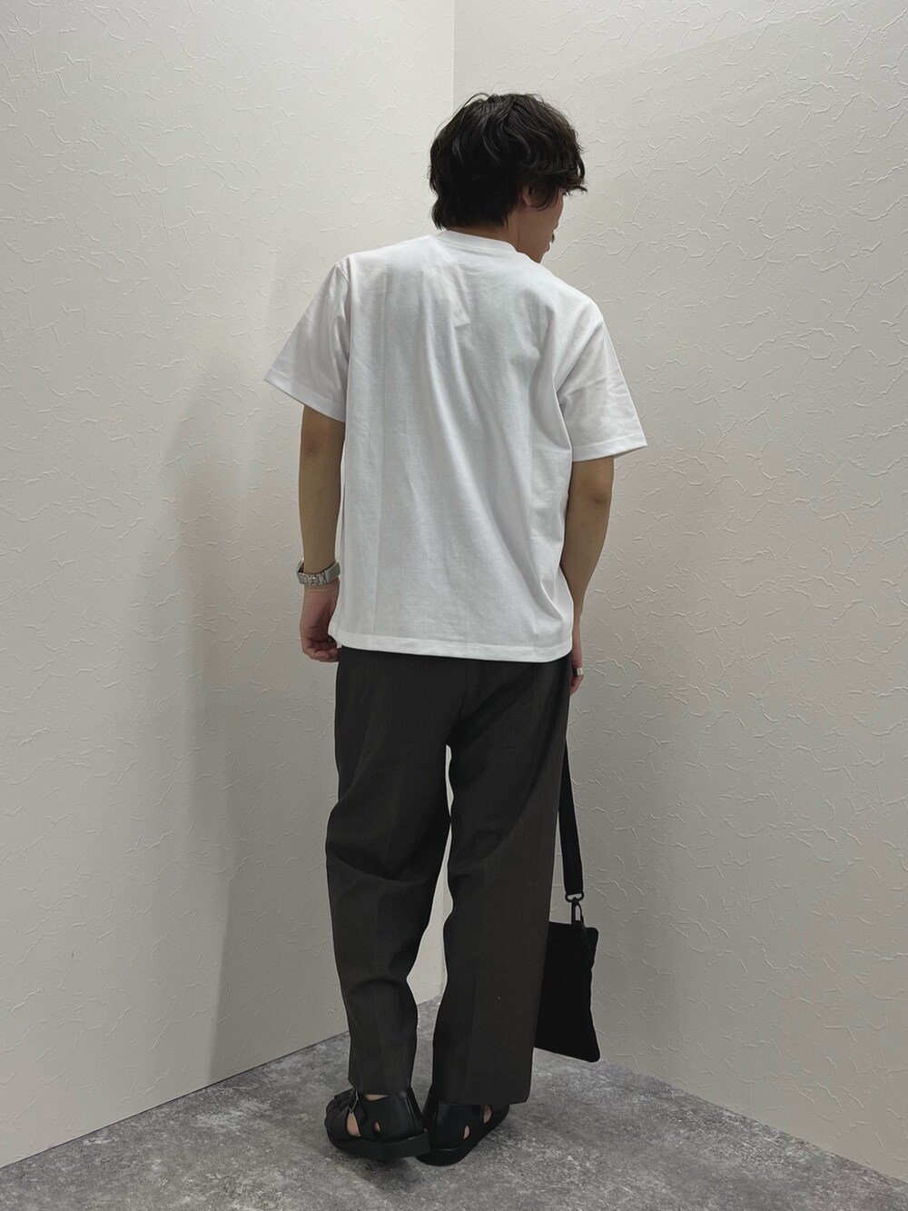 ホワイト系のTシャツ/カットソー、ブラック系のショルダーバッグ、ブラック系のサンダルを着用したメンズの春コーディネートの7枚目の写真