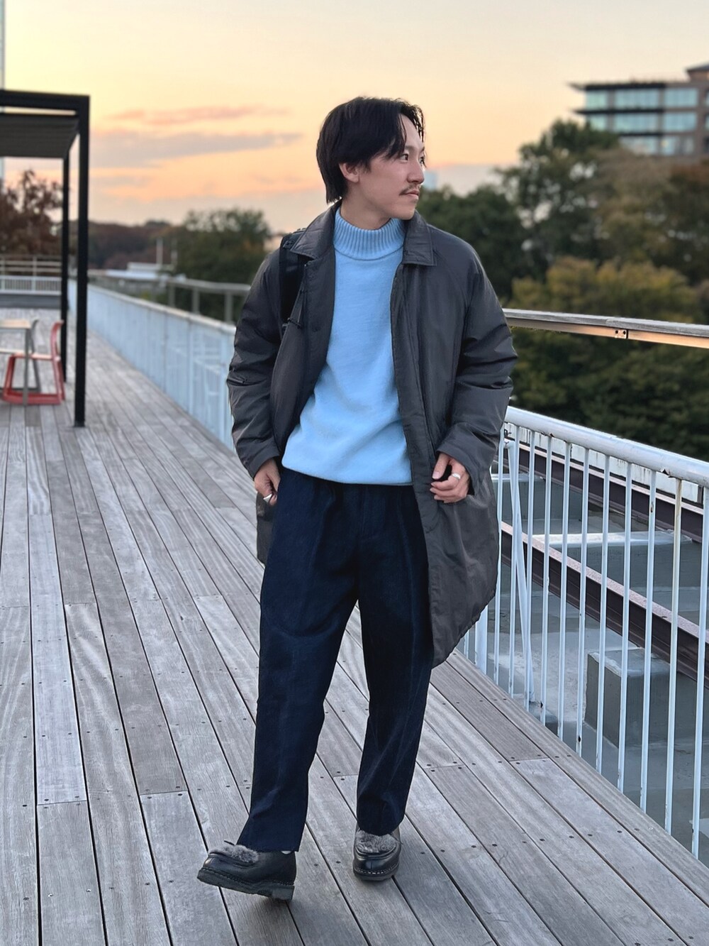 グレー系のダウンジャケット/コート、ブルー系のニット/セーター、ブラック系のバックパック/リュックを着用したメンズの冬コーディネートの3枚目の写真