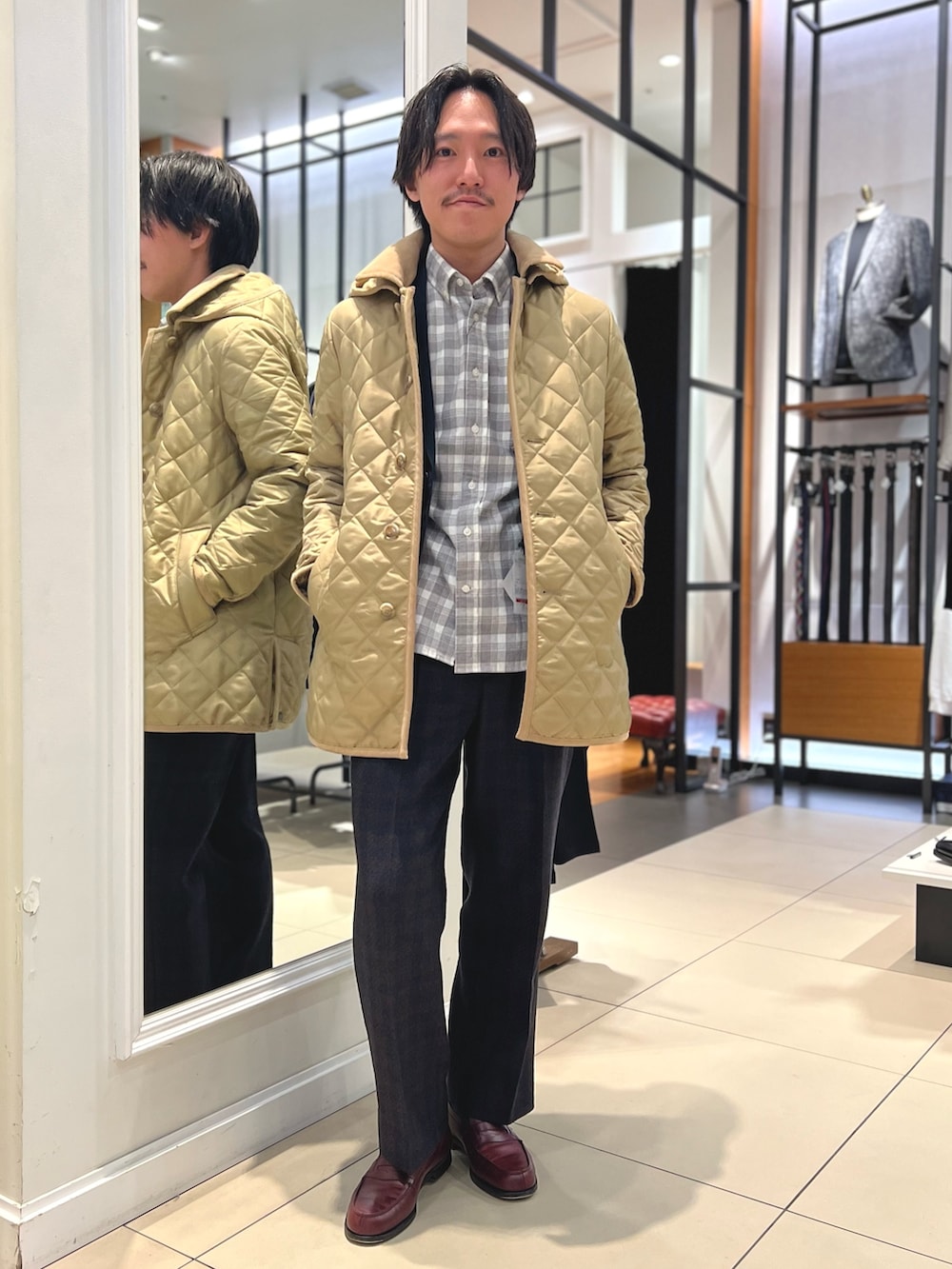 ベージュ系のブルゾン、ブルー系のテーラードジャケット、ブラウン系のローファーを着用したメンズの冬コーディネートの5枚目の写真