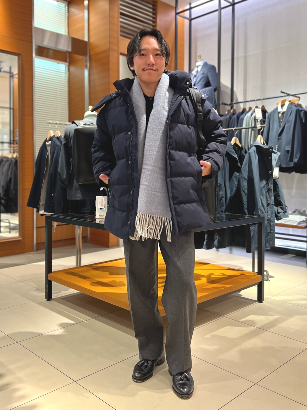 ブルー系のダウンジャケット/コート、ブラック系のトートバッグ、ブラック系のローファーを着用したメンズの冬コーディネートの4枚目の写真