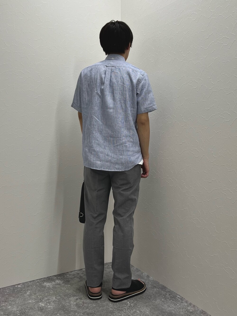 ブルー系のシャツ/ブラウス、ブラック系のボディバッグ/ウエストポーチ、グレー系のチノパンツを着用したメンズの春コーディネートの5枚目の写真