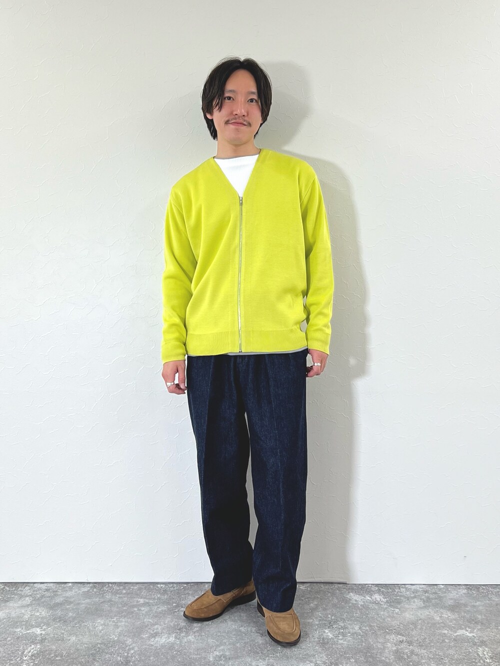 イエロー系のカーディガン/ボレロ、ホワイト系のTシャツ/カットソー、ブルー系のデニムパンツを着用したメンズの冬コーディネートの4枚目の写真