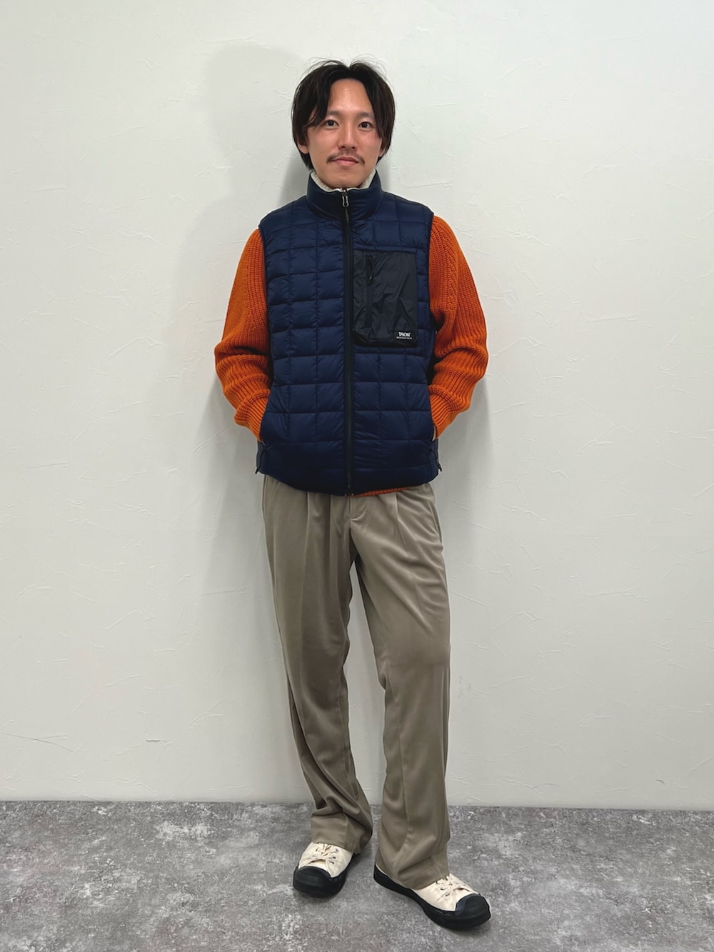 ホワイト系のダウンベスト、ベージュ系のその他パンツを着用したメンズの秋コーディネートの6枚目の写真