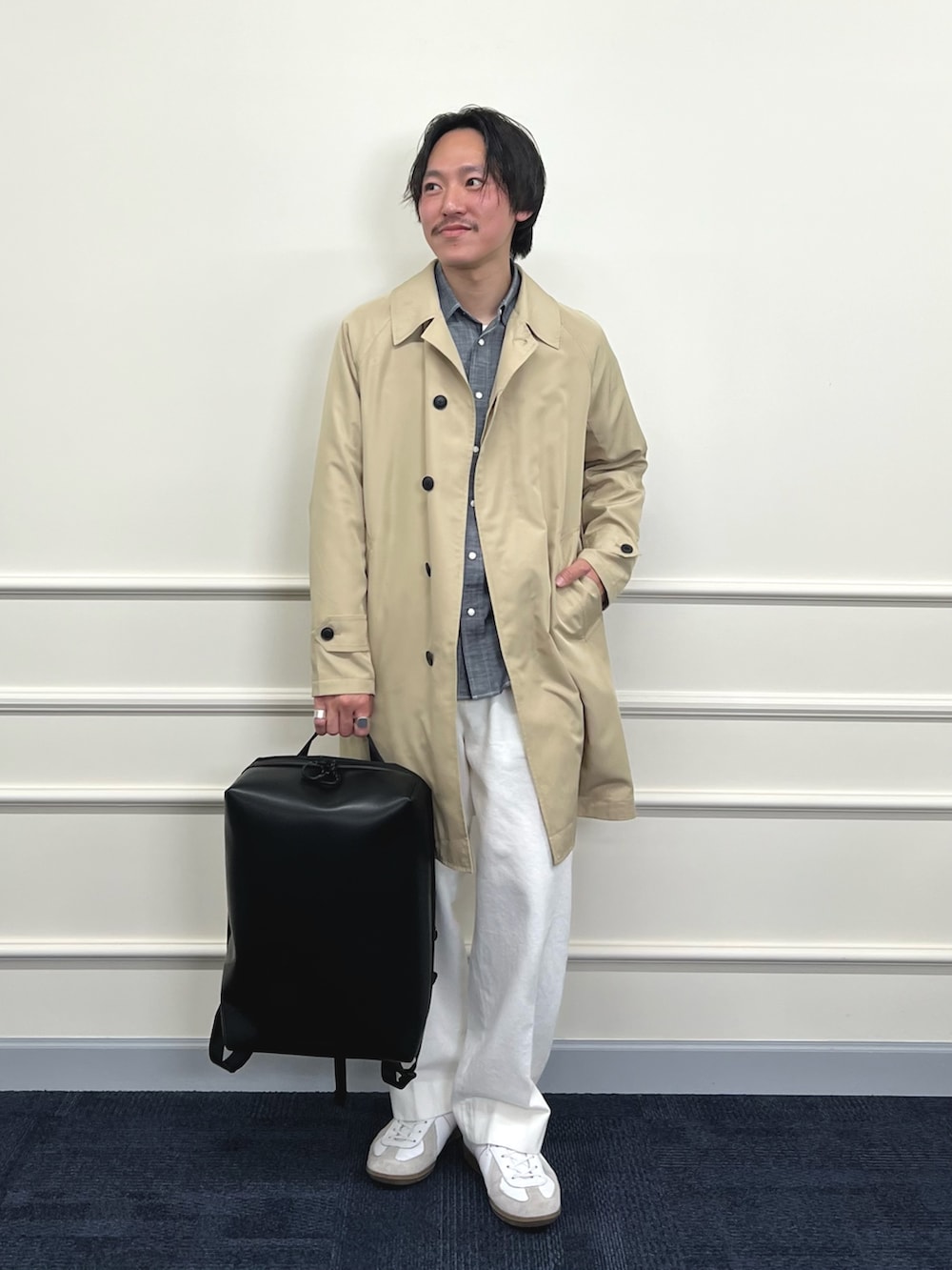 ベージュ系のステンカラーコート、ブラック系のシャツ/ブラウス、ホワイト系のデニムパンツを着用したメンズの冬コーディネートの2枚目の写真