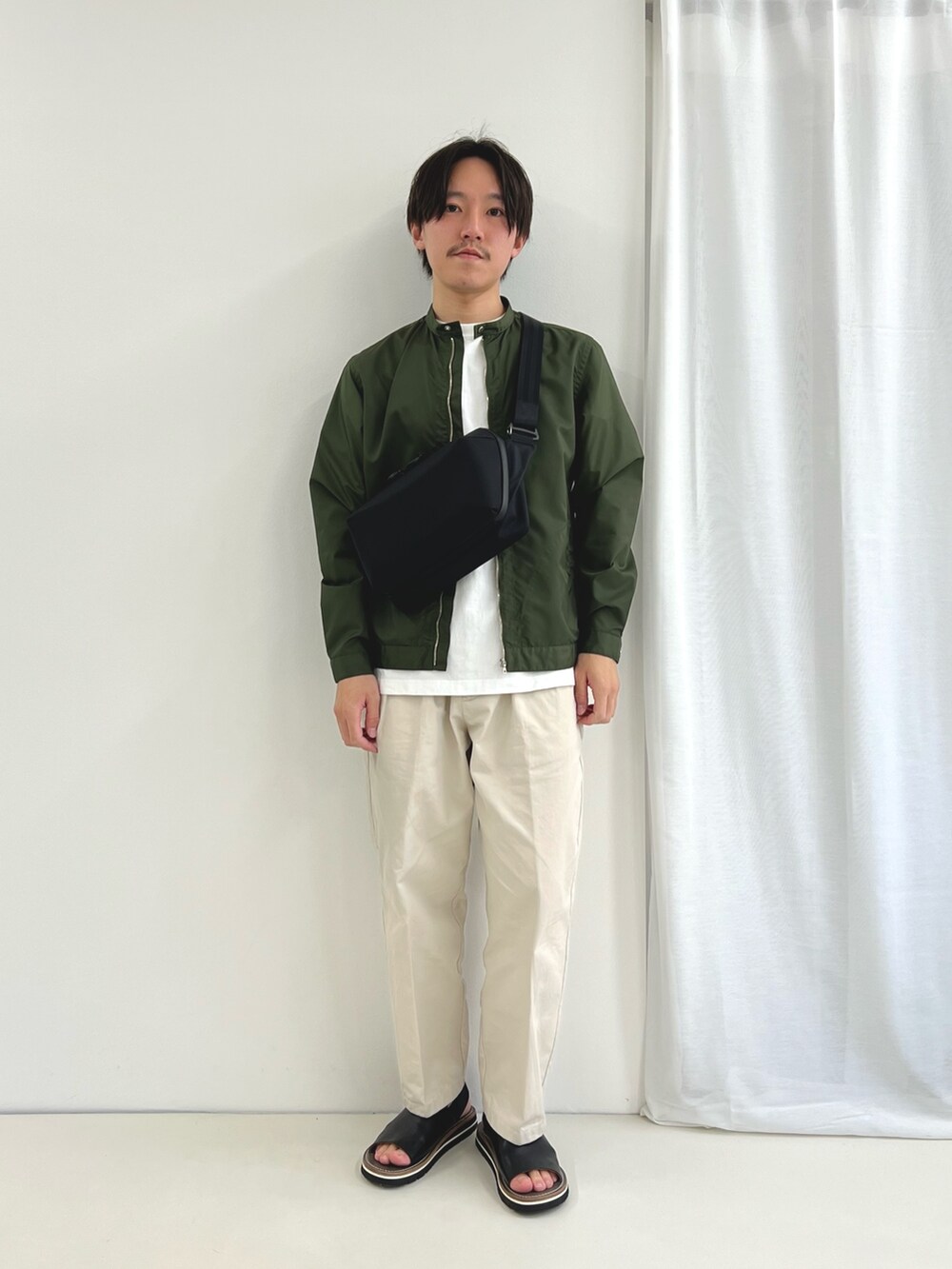 ホワイト系のTシャツ/カットソー、ブラック系のショルダーバッグ、ブラック系のサンダルを着用したメンズの春コーディネートの2枚目の写真