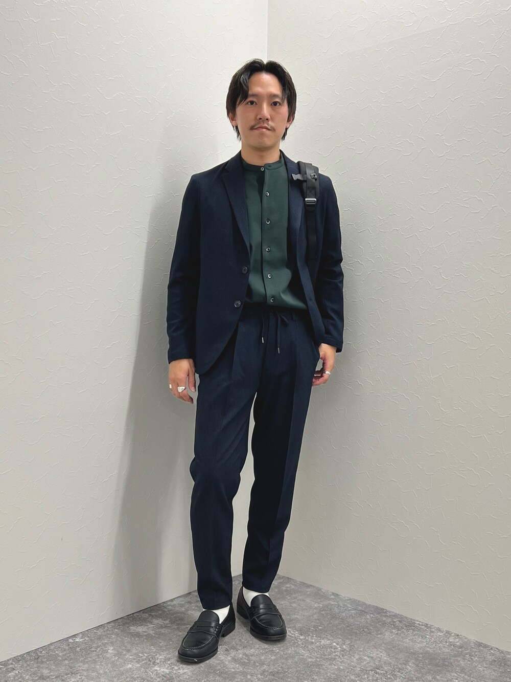 ブルー系のテーラードジャケット、ブルー系のその他パンツ、ブラック系のバックパック/リュックを着用したメンズの秋コーディネートの2枚目の写真