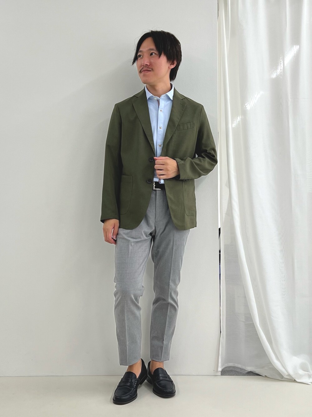 ブルー系のシャツ/ブラウス、グレー系のチノパンツ、グリーン系のテーラードジャケットを着用したメンズの夏コーディネートの2枚目の写真