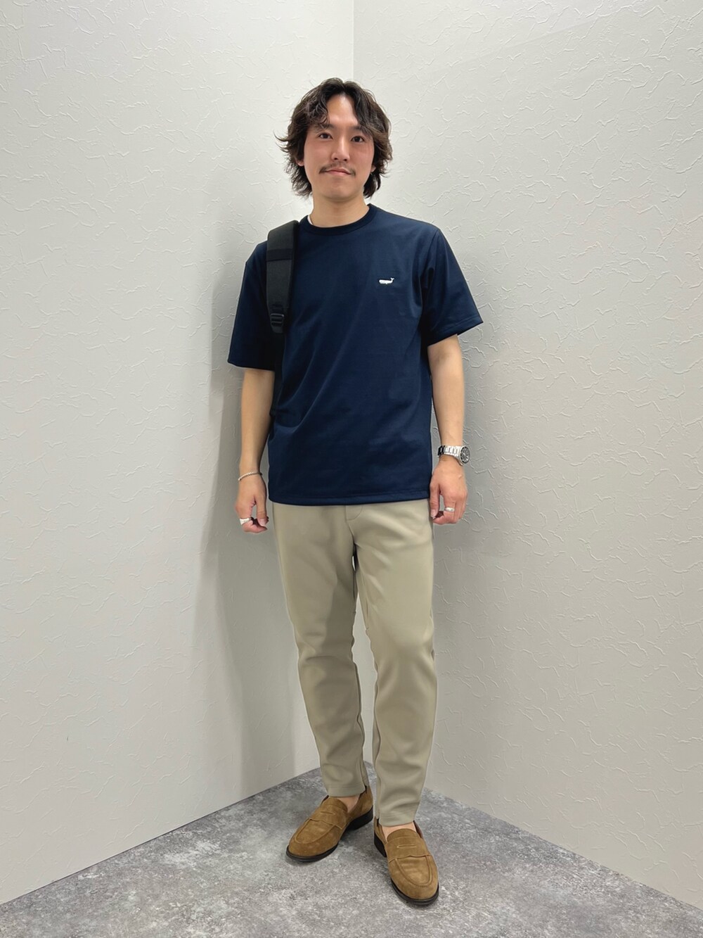 ブルー系のTシャツ/カットソー、ブラック系のバックパック/リュック、グリーン系のその他パンツを着用したメンズの春コーディネートの3枚目の写真