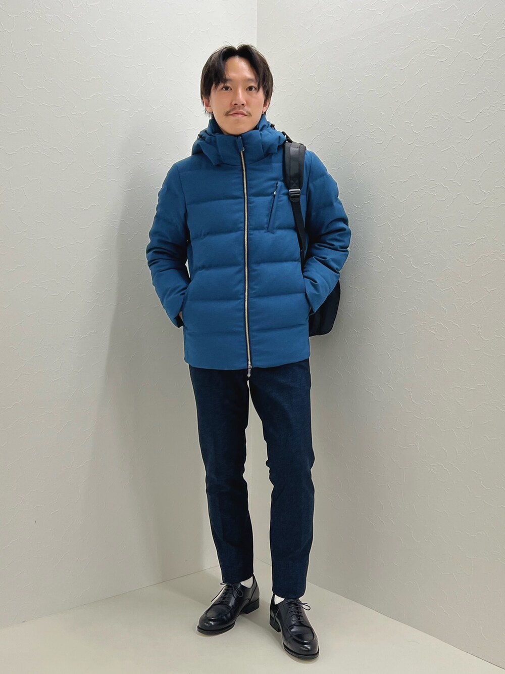 パープル系のニット/セーター、ブルー系のダウンジャケット/コート、ブラック系のバックパック/リュックを着用したメンズの秋コーディネートの3枚目の写真