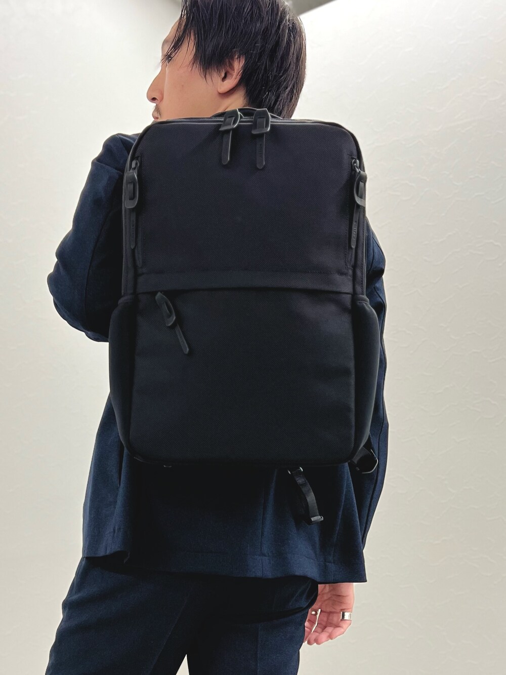 ブルー系のテーラードジャケット、ブルー系のその他パンツ、ブラック系のバックパック/リュックを着用したメンズの秋コーディネートの5枚目の写真