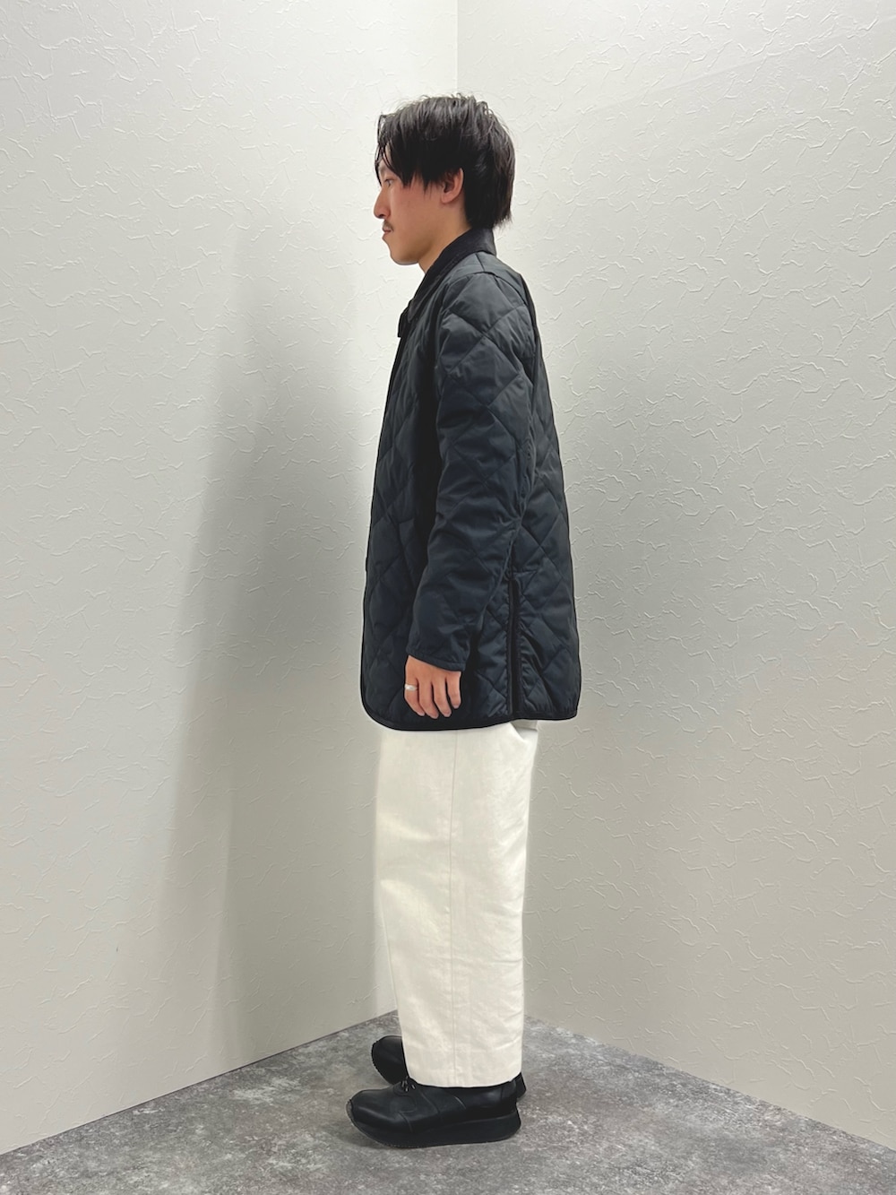 ブラック系のダウンジャケット/コート、ブラック系のTシャツ/カットソー、ブラック系のスニーカーを着用したメンズの秋コーディネートの4枚目の写真