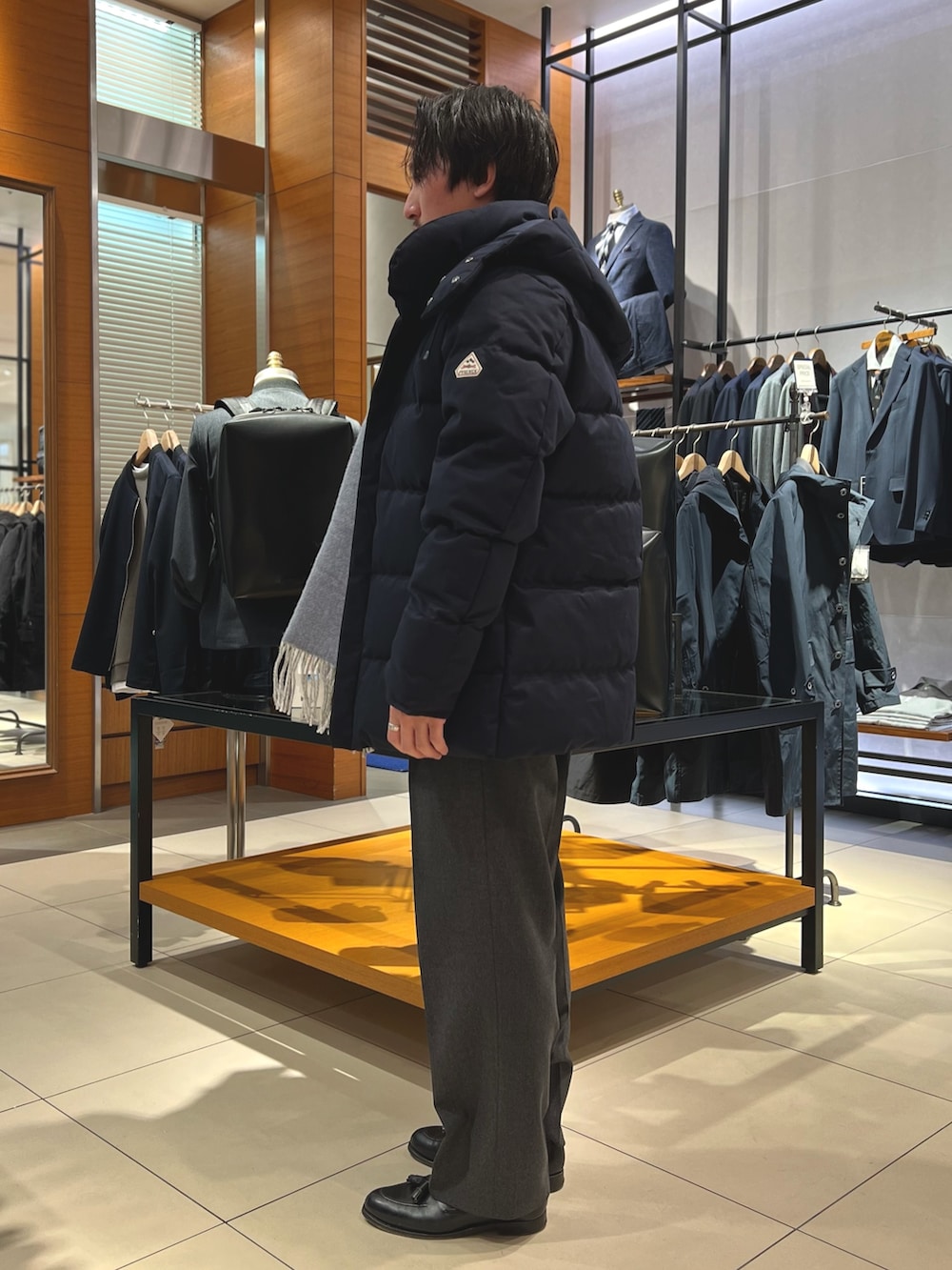 ブルー系のダウンジャケット/コート、ブラック系のトートバッグ、ブラック系のローファーを着用したメンズの冬コーディネートの5枚目の写真