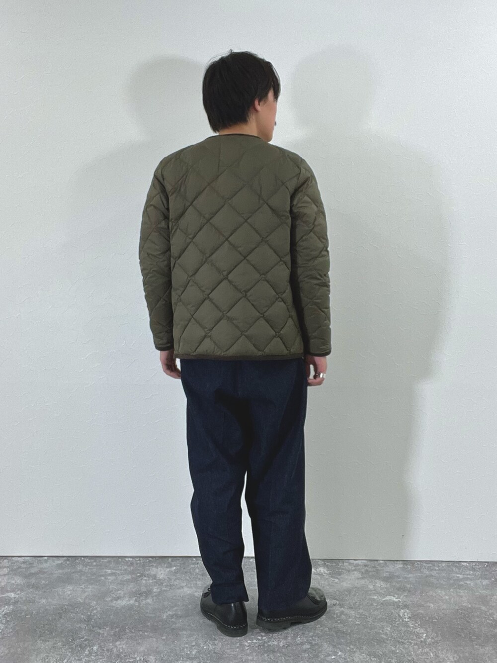 グリーン系のダウンジャケット/コート、ホワイト系のスウェット、ブラック系のブーツを着用したメンズの秋コーディネートの6枚目の写真