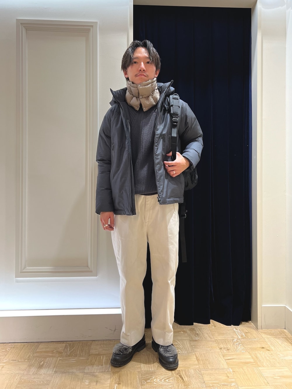 ブラック系のバックパック/リュック、グレー系のブルゾン、グリーン系のネックウォーマー/スヌードを着用したメンズの冬コーディネートの2枚目の写真