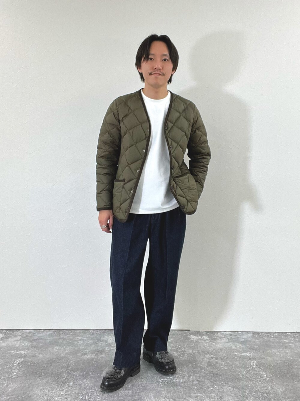 グリーン系のダウンジャケット/コート、ホワイト系のスウェット、ブラック系のブーツを着用したメンズの秋コーディネートの2枚目の写真